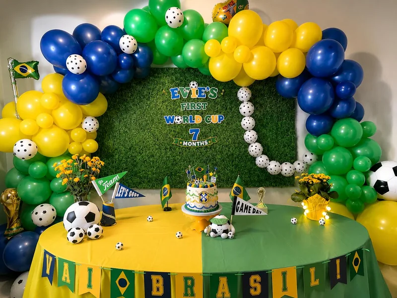 Green, yellow and blue balloon garlands, soccer ball accents and a coordinated Brazil-themed dessert table.